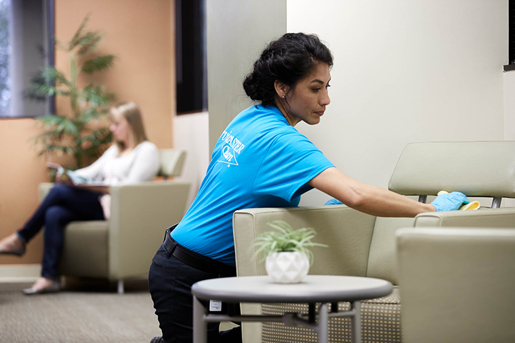 Female staff cleaning office waiting room chair